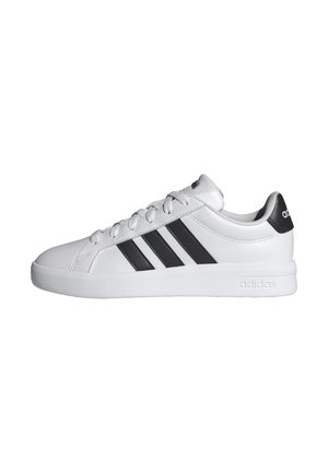 Sneaker bianca Adidas con tre strisce nere sul lato, lacci bianchi e linguetta nera sul tallone con logo Adidas.