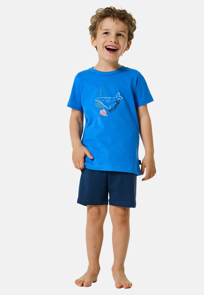 T-shirt di cotone blu con grafica di balena e pesci, abbinata a pantaloni corti blu scuro. La maglietta ha un collo rotondo e maniche corte.