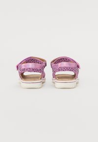 Rosa sandaler med ett leopardmönster, med utskurna sidor och justerbara remmar. Vita sulor med en lätt texturdetalj.