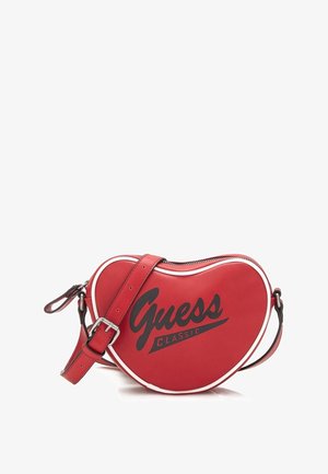 Rode hartvormige Guess Classic crossbodytas met verstelbare band en witte rand op een witte achtergrond.