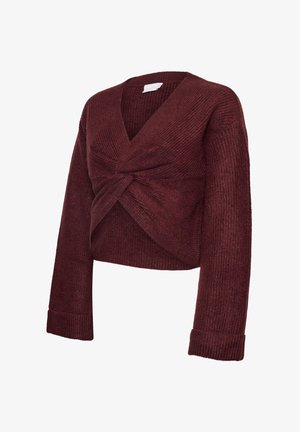 Pull court bordeaux avec un décolleté en V profond, un devant torsadé, une texture côtelée et des manches larges. Matière tricotée douce avec une coupe décontractée.