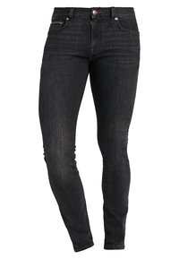 Smala jeans i svart denim. Funktioner inkluderar en klassisk fem-fickorsdesign, kontrasterande sömmar och en dragkedja med knappstängning.