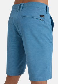 Blauwe shorts van textiel met een structuur. Kenmerken zijn onder andere twee achterzakken, een ritsdetail en een tailleband met riemlussen.