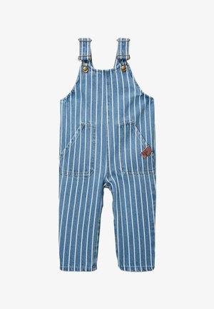 Salopette en denim bleu avec des rayures blanches verticales, bretelles réglables avec boutons en laiton, deux poches plaquées à l'avant, et une petite étiquette avec le drapeau américain.