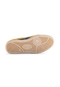 Sole sneaker Gabor s texturovanou gumovou podrážkou, která má vzor rybí kosti a kruhové logo. Převážně žlutá s černými akcenty.