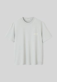 T-shirt en coton gris clair avec un col rond et des manches courtes, présentant un petit imprimé texte de couleur claire avec l'inscription "Projet en cours."