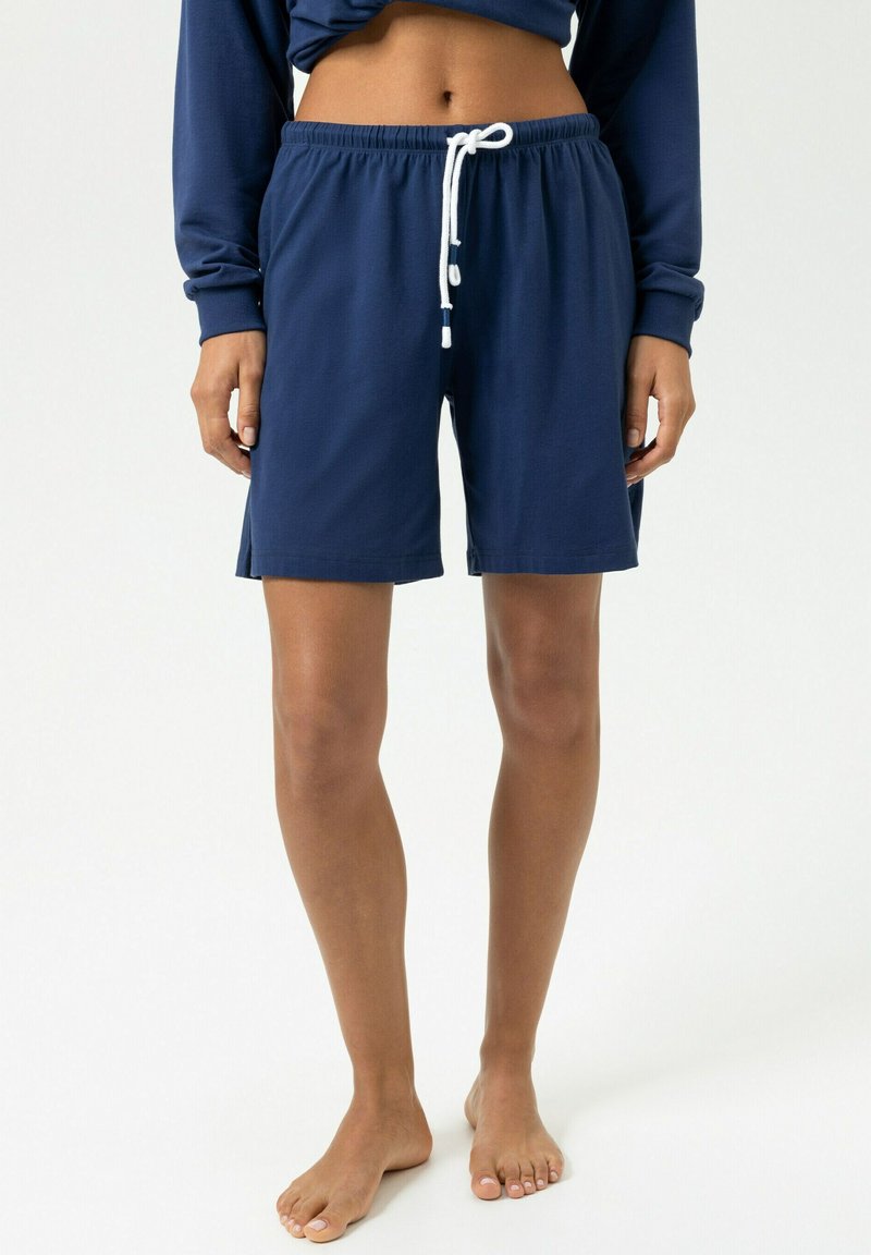Shorts bleu marine en tissu doux avec une ceinture élastique, dotés d'un cordon de serrage blanc. Ils ont une coupe droite, arrivant à mi-cuisse.