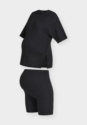 Top negru pentru maternitate, cu mânecă scurtă, cu dungi și pantaloni scurți pentru maternitate cu talie înaltă asortați, din material elastic și cu fante laterale pe top.