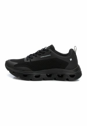 Zapatillas deportivas negras con parte superior de malla, suela acolchada y acentos texturizados. Presentan cordones y una pequeña pestaña en la parte trasera.