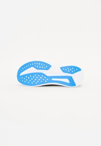 Semelle de chaussure avec un dessus noir et des accents bleus. Présente des motifs texturés et des perforations blanches pour une meilleure traction. Design léger et flexible.