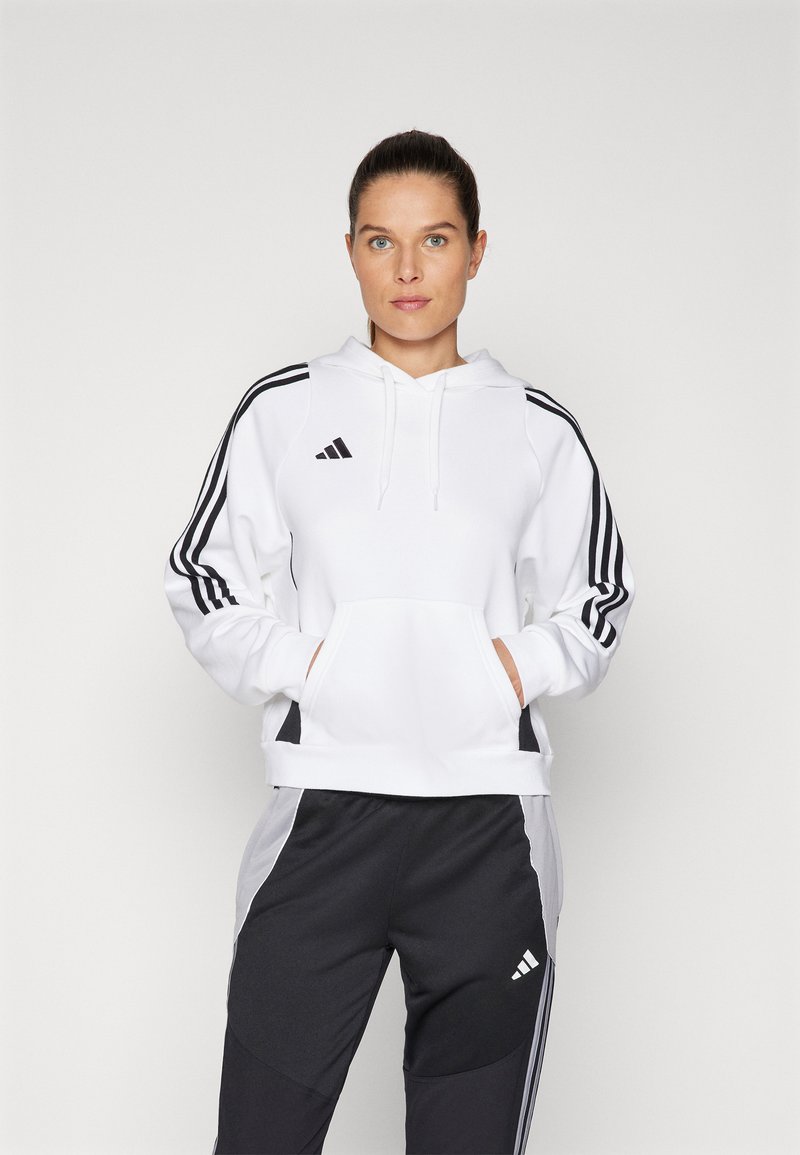 White hoodie with black three-stripe accents, kangaroo pocket, and hood. Paired with black joggers featuring a subtle logo and color-block design.