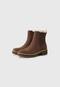 Botas de tobillo de ante marrón con suela de goma, con un borde de piel sintética en la parte superior y paneles laterales elásticos para facilitar su uso.