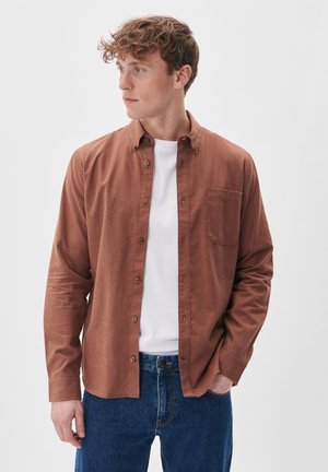 Brown button-up shirt with a pocket, paired with a white T-shirt and blue jeans. Soft texture, casual fit, and subtle button details.