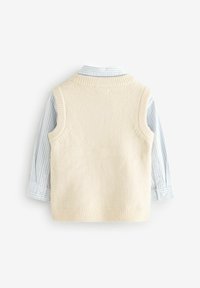 Gilet en tricot crème par-dessus une chemise à rayures bleu clair à manches longues. Le gilet a un col et des emmanchures côtelés, avec des poignets à boutons.