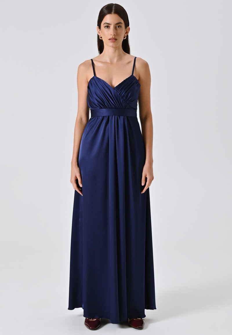 Navy blauwe satijnen maxi-jurk met dunne bandjes, geplooide buste en een getailleerde taille. Gladde textuur met een vloeiende silhouette.