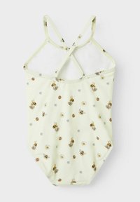Maillot de bain jaune clair avec des bretelles croisées, présentant un motif floral et d'abeilles en brun, blanc et bleu sur un tissu lisse.