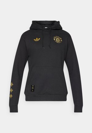 Μαύρο φούτερ με κουκούλα από βαμβάκι με εμπρόσθια τσέπη. Διαθέτει χρυσό λογότυπο της Manchester United, λογότυπο Adidas και χρυσές λεπτομέρειες στα μανίκια.