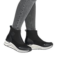 Botines negros con un diseño elegante, fabricados con materiales sintéticos. Presentan un upper texturizado, cierre de cremallera y suela de rayas blancas.