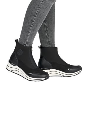 Bottines noires à la cheville au design élégant, fabriquées en matériaux synthétiques. Caractéristiques : tige texturée, fermeture à glissière et semelle rayée blanche.