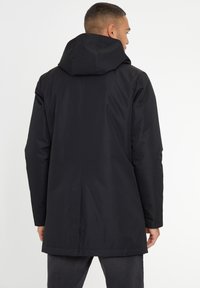 Zwarte waterdichte parka met een capuchon, lange mouwen, een rechte snit en een minimalistisch ontwerp. Glad oppervlak zonder zichtbare patronen.
