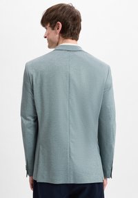 Heren blazer op maat in lichtblauw, van een gestructureerde stof. Bevat een enkele split aan de achterkant en knoopmanchetten, met een soepele, gestructureerde silhoeët.