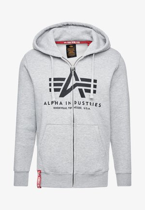 Šedá mikina na zip vyrobená z měkké látky, se velkým černým logem a dvojicí předních kapes. Stahovací šňůrky na kapuci a pružné manžety.