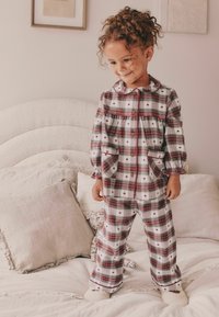 Gestreiftes Schlafanzugset in Rot und Weiß mit kleinen Herzmustern. Verfügt über Knopfverschluss und zwei Taschen, kombiniert mit weichen Hausschuhen.