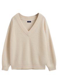 Beige gestrickter Pullover mit V-Ausschnitt, gerippter Textur und weiten Ärmeln. Der untere Saum ist gerade, und das Markenetikett ist am Halsbereich sichtbar.