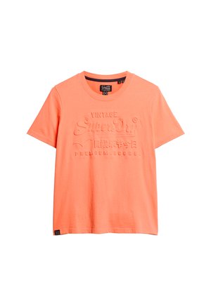 Korte mouwen t-shirt van helder koraal katoen, met een reliëflogo-tekst op de voorkant. Klassieke ronde hals met een standaard pasvorm.