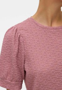 Lichtroze, textuur blouse met korte pofmouwen en een ronde halslijn, met een bloemetjespatroon en een zachte, lichtgewicht stof.