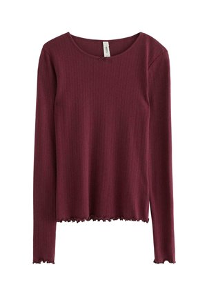 Bordeaux lange mouw top in ribbelstof met een ronde hals en een golvende rand. De textuur lijkt zacht en iets rekbaar.