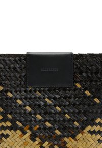 Woven bag z plecionki z czarnymi i naturalnymi wzorami słomkowymi, gładkim akcentem z czarnej skóry i prostokątnym kształtem.