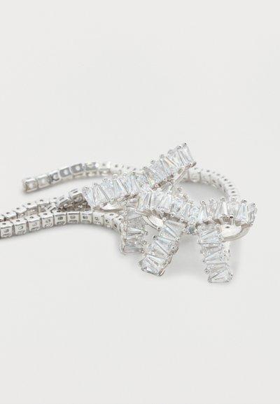 Κρύσταλλο βραχιόλι με εναλλασσόμενα ορθογώνια και τετράγωνα σχήματα, τοποθετημένα σε ασημί μεταλλική λωρίδα με ευέλικτο σχεδιασμό.