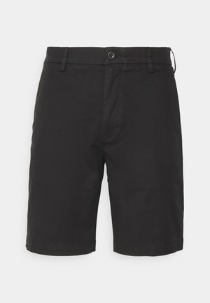 Sorte bomullsshorts med knappelukking, flat foran, side lommer og sømmer. Stoffet ser glatt og matt ut.