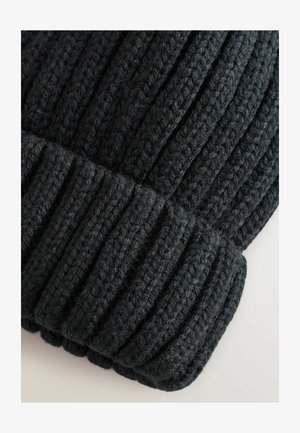 Bonnet en tricot noir avec une texture côtelée. Il présente un revers et est fabriqué en fil épais et doux pour la chaleur et le confort.