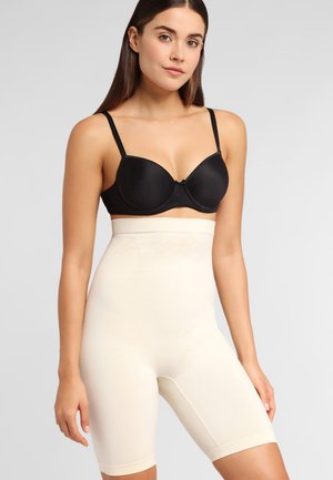 Beige shapewear shorts made of smooth, stretchy fabric, featuring a high waistband and seamless design for a sleek appearance.