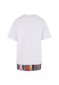 Tricou alb cu mânecă scurtă, cu un croi drept, având o bordură din material cu un model colorat la marginea de jos.