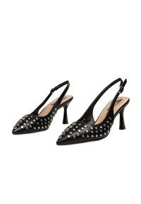 Zapatos slingback de cuero negro con puntas afiladas, que presentan acentos de tachuelas plateadas en la parte delantera y un tacón de altura media.