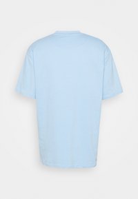 Jasnoniebieska koszulka z krótkim rękawem pokazana z tyłu, gładki design, okrągły dekolt i luźny krój.