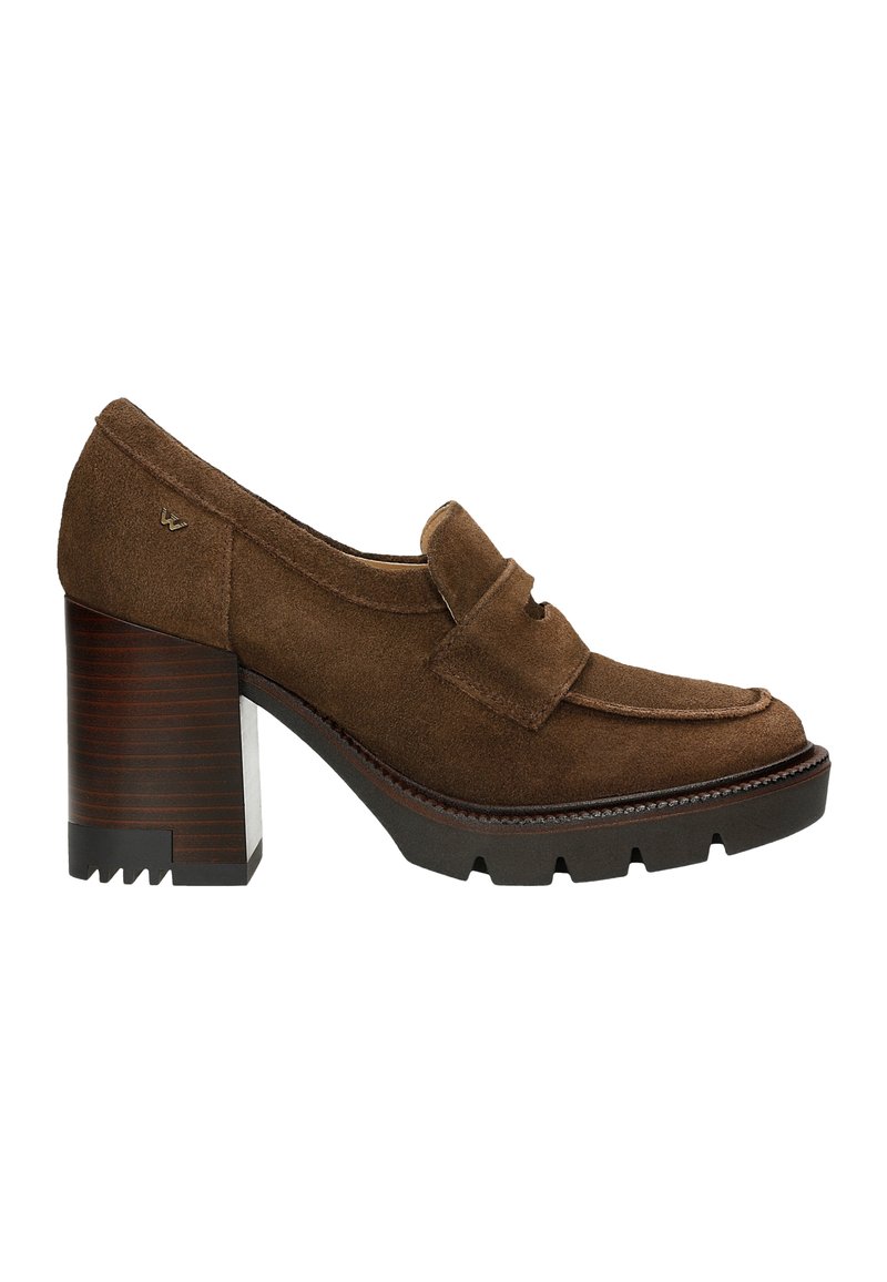 Mocassins à talons en suède brun avec un bout arrondi, dotés d'une sangle décorative, d'un talon bloc texturé et d'une semelle rugueuse pour une meilleure adhérence.