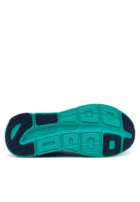 La semelle de la chaussure présente un design texturé avec une couleur bleu-vert et des accents plus foncés. Elle comprend des rainures flexibles et un logo bien en vue.