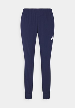 Mörkblå joggerbyxor i mjukt tyg, med elastisk midja och muddar, samt en liten vit logotyp på sidan.