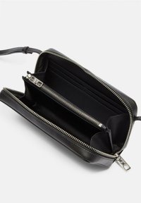 Czarny skórzany portfel z zamknięciem na zamek błyskawiczny, z wieloma przegródkami, miejscami na karty i zamkami w kolorze srebrnym, zapewniającymi bezpieczny dostęp.