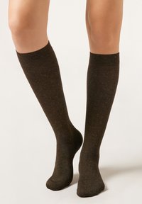 Knee-high socks in dark brown with a subtle textured pattern. Soft material with reinforced cuffs and a smooth finish.