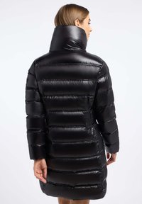 Zwarte pufferjas met een hoge kraag, voorzien van een glanzende, gladde textuur en een horizontaal gestikt ontwerp. De mouwen zijn iets los met een rechte snit.