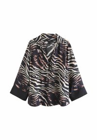 Chemise rayée noir et blanc avec fermeture à liens, coupe ample et manches longues. Présente des poignets noirs unis contrastants. Texture du tissu lisse.