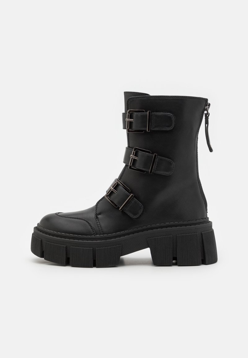 Botte noire mi-mollet avec semelle épaisse, trois sangles réglables à boucle à l'avant et une fermeture éclair à l'arrière.
