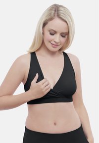 Schwarzer Bralette mit tiefem V-Ausschnitt, breiten Trägern und gerafftem Frontdesign. Glatte Textur und keine sichtbaren Verschlüsse oder Befestigungen.