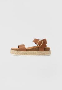 Sandali in pelle marrone con un'unica fascia anteriore e una fascia alla caviglia, con una fibbia dorata e suola platform avvolta in juta.