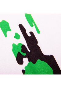 Abstracte zwarte en groene verfspetters op een witte textuurstof achtergrond, die een onregelmatig patroon creëren.